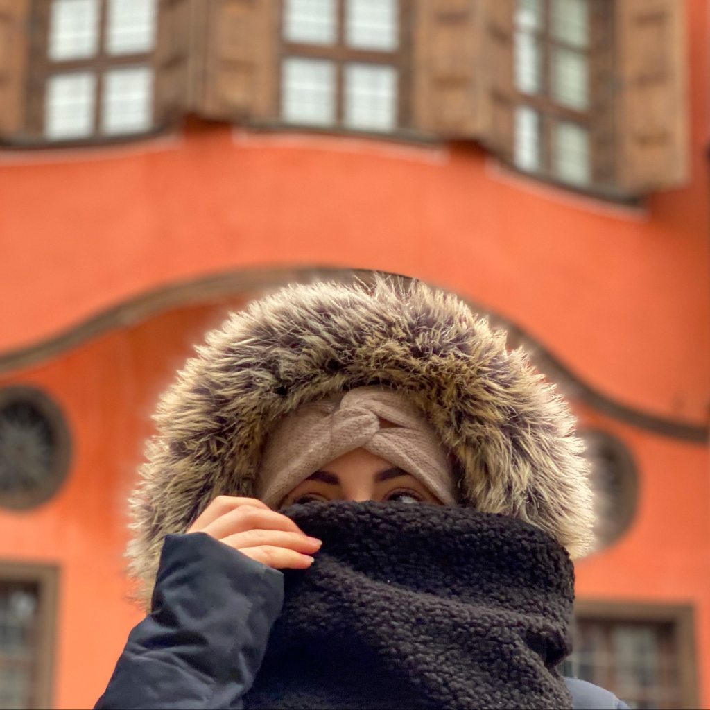 girl in hoodie with orange house in background